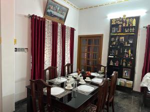 a dining room with a table with chairs and red curtains at Rare Rabbit Munnar in Anachal