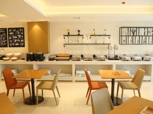 restauracja ze stołami i krzesłami oraz kuchnia w obiekcie City Comfort Inn Maoming Binhai New Area Diancheng 