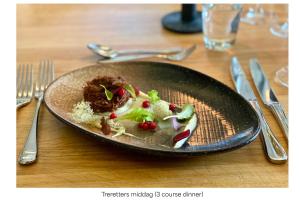 a black plate of food on a wooden table at Turtagrø Hotel in Fortun +17 photos