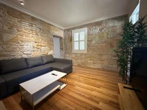 a living room with a couch and a stone wall at 2 Bedroom Family Friendly Ultimo Near the Centre 2 E-Bikes Included in Sydney