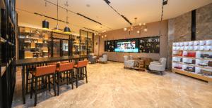 un restaurante con sillas y un bar en una habitación en Echarm Hotel Mianyang Changhong Avenue Kaide Plaza, en Mianyang