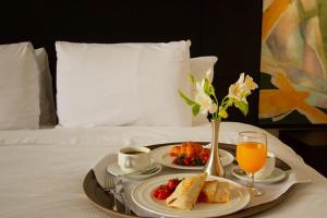 a tray with food and drinks on a bed at ADRIATIKA Hotel Boutique Guatemala - Adults Only in La Aurora