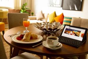 a coffee table with a laptop and a plate of food at ADRIATIKA Hotel Boutique Guatemala - Adults Only in La Aurora