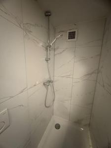 a bathroom with a shower with white marble walls at Hello Noordwijk - Zomerhuis Quarles van Uffordstraat 89 in Noordwijk