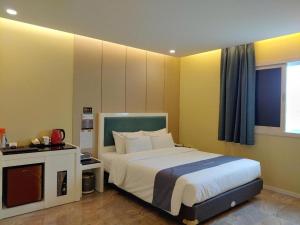 a bedroom with a large bed and a television at jeju illua hotel in Jeju