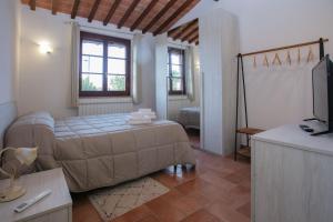 a bedroom with a bed and a tv in it at Agriturismo Il Sogno in Castiglione del Lago