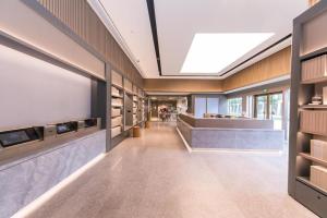 um átrio de escritório com uma grande televisão e um longo corredor em Ji Hotel Shanghai Hongqiao Gubei Fortune Center em Xangai