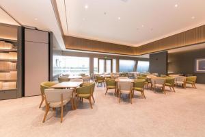 um restaurante com mesas e cadeiras num quarto em Ji Hotel Shanghai Hongqiao Gubei Fortune Center em Xangai