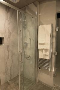 a shower with a glass shower stall in a bathroom at The Leonard Hotel in London