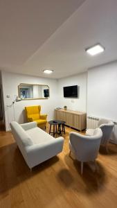 a living room with a white couch and a yellow chair at Apartamento de Lucerito in Jaca