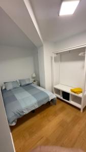 Dormitorio blanco con cama y estante blanco en Apartamento de Lucerito, en Jaca