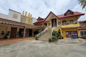 een geel huis met trappen op een parkeerplaats bij Sunny Point Hotel in Pequeno