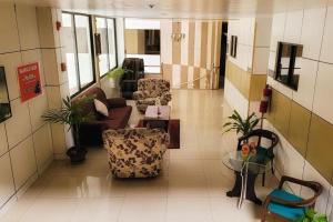 un couloir avec des canapés et des chaises dans un bâtiment dans l'établissement Sunny Point Hotel, à Pequeno