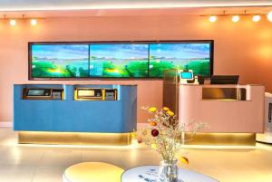 um quarto com uma grande televisão na parede em Hanting Hotel Binzhou Bohai International Plaza em Binzhou