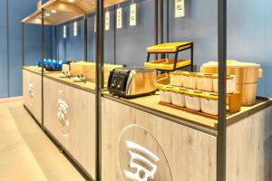 a bakery counter with a toaster and other food items at Hanting Hotel Binzhou Bohai International Plaza in Binzhou
