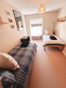 1 dormitorio con 2 camas, 1 cama y ventana en Cosy House Close To Stunning Beaches en Braunton