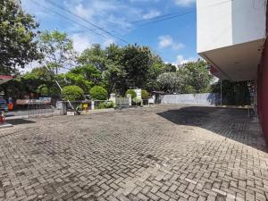 a cobblestone parking lot in front of a building at Aries Hotel Lampung in Kedaton