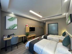 a hotel room with two beds and a desk at Thank Inn Jiangsu Suqian Sucheng District Car Town in Suqian