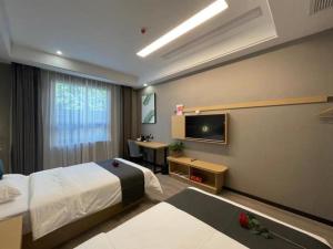 a hotel room with a bed and a television at Thank Inn Jiangsu Suqian Sucheng District Car Town in Suqian