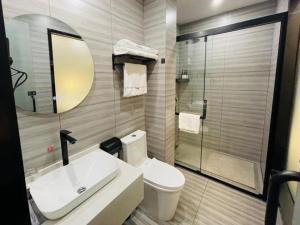 a bathroom with a toilet and a sink and a mirror at Thank Inn Jiangsu Suqian Sucheng District Car Town in Suqian