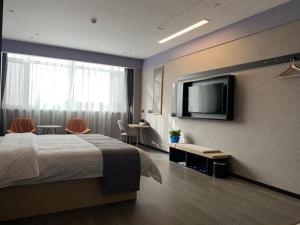 a hotel room with a bed and a flat screen tv at Thank Inn Ningxia Yinchuan Helan County Ningxia Jiaotong School in Yinchuan