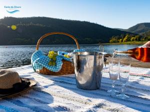 a picnic table with a bottle of wine and glasses at Canto Zêzere, Barragem de Castelo do Bode in Cernache do Bonjardim