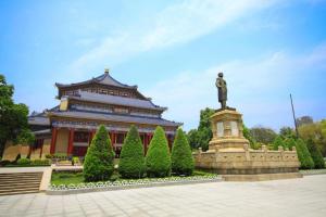 a large building with a statue in front of it at Ausotel Smart (Zhujiang Newtown Guangzhou) in Guangzhou