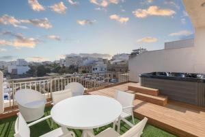 un balcón con mesas blancas y sillas en el techo en Modern two bedroom penthouse! en St Julian's