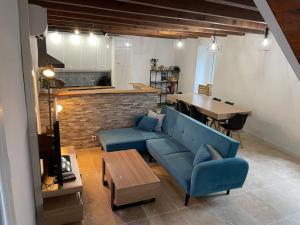 Lou Castel في Pomérols: غرفة معيشة مع أريكة زرقاء وطاولة