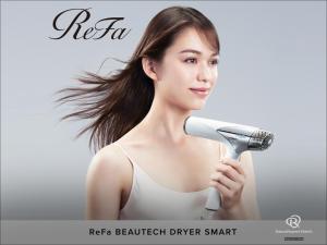 a young woman holding a hair dryer at Daiwa Roynet Hotel Osaka Sakaisuji Honmachi PREMIER in Osaka