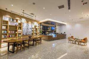 a restaurant with tables and chairs and a library at Hanting Hotel Heze Zhonghua Road Ginza in Heze