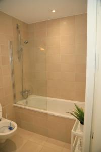 a bathroom with a shower and a tub and a toilet at cosy and prime location in Sheffield