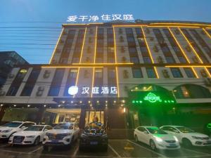 Hanting Hotel Hefei Baoye Dongcheng Plaza في خفي: مبنى فيه سيارات تقف امامه