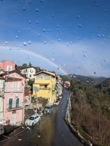 a rain soaked view of a street with a rainbow at Villa Ermetica in Breil-sur-Roya