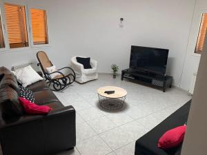 sala de estar con sofá y TV de pantalla plana en SeaHomes Vacations - VILLA ROYER, en Tordera