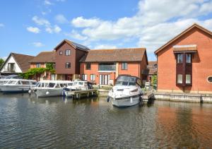 a group of boats docked at a house on the water at Marina Outlook in Horning