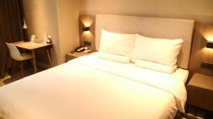 Un pat sau paturi într-o cameră la Hanting Hotel Shijiazhuang Railway Station Xi Square