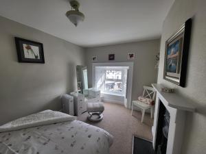 a bedroom with a bed and a desk and a window at Charming 2-Bed Apartment in Donegal Town Centre in Donegal