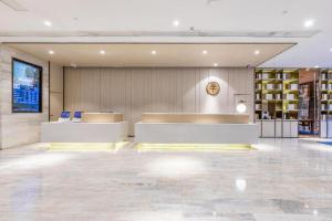a lobby with a reception desk in a building at Ji Hotel Wuhan Guanggu Software Park Minzu Avenue in Liufangling