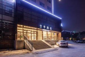 a building with a car parked in front of it at Ji Hotel Wuhan Guanggu Software Park Minzu Avenue in Liufangling