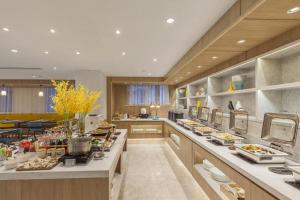 a large kitchen with a lot of food on the counters at Hanting Premium Hotel Ji'nan Quancheng Road in Jinan