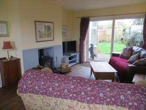 a living room with a couch and a tv at Rowan House in Hunstanton
