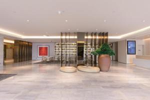 a lobby with a potted plant in a building at Ji Hotel Ordos Wanzheng Plaza in Zhaoyoufang