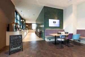 un restaurante con mesa, sillas y barra en the niu Wave - Apartments, en Karlsruhe