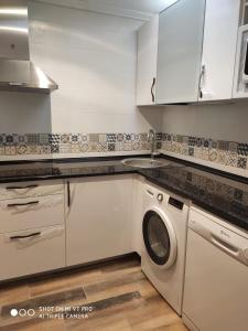 a kitchen with a washing machine and a sink at Luz de la Bahía II - Bahía Sur - Cádiz in San Fernando