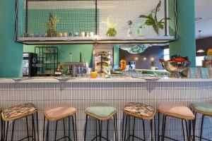 a bar with four stools in front of a counter at the niu Wave - Apartments in Karlsruhe