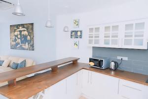 a kitchen with white cabinets and a wooden counter top at Crown Properties in Colombo