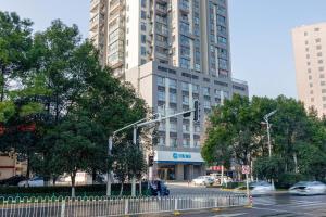 a traffic light in front of a large building at Hanting Hotel Wuhan Guanggu Plaza in Liufangling