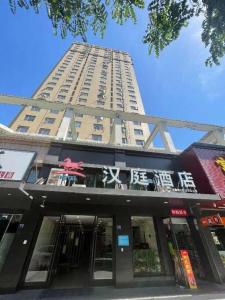 un edificio alto con una tienda delante en Hanting Hotel Wuhan MinHang Xiaoqu en Wuhan