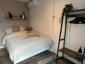 a bedroom with a bed with a table on it at Hello Noordwijk - Studio Pietheinplein 1 in Noordwijk